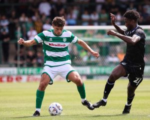 Trialist Byron Pendleton takes on a Bristol Rovers player.