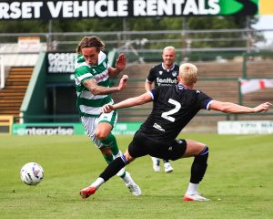 Trialist Luke McCormick runs past a Bristol Rovers player in a pre-season friendly match.